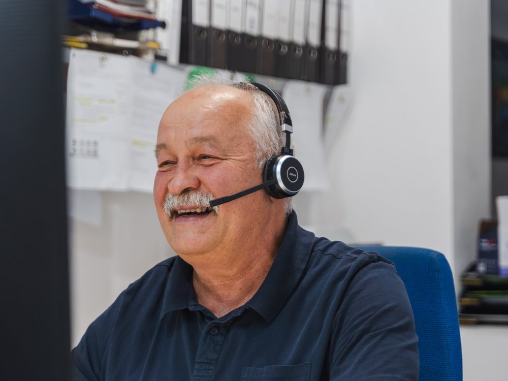 Zoltan Gal with headset at his desk in the Nuremberg office